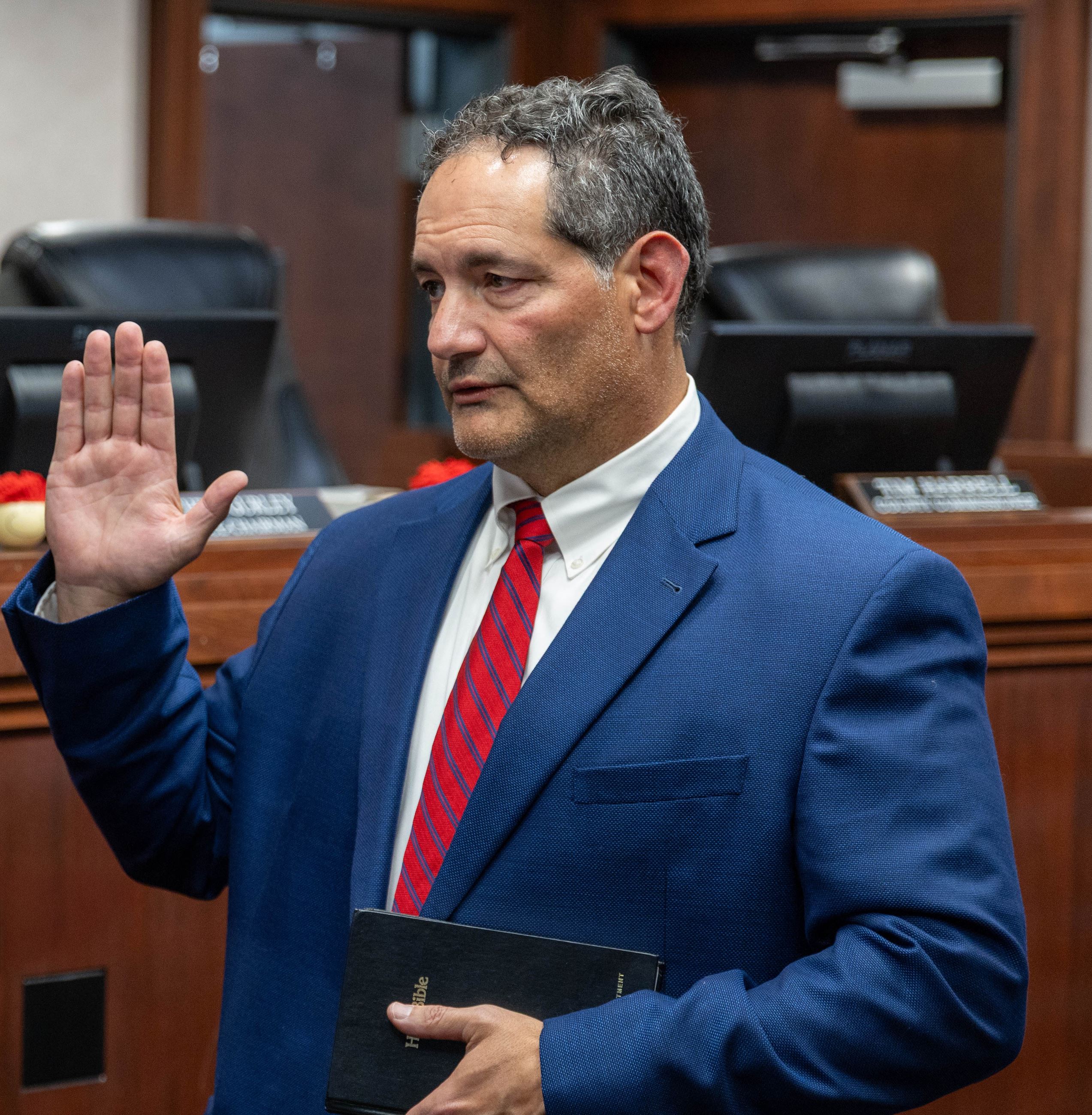 Dr. Democko with his hand raised being sworn into office