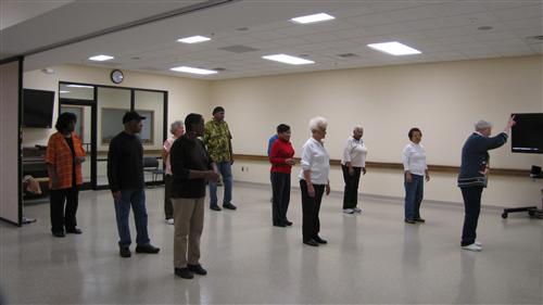 Members of the Songbirds stand up and rehearse.